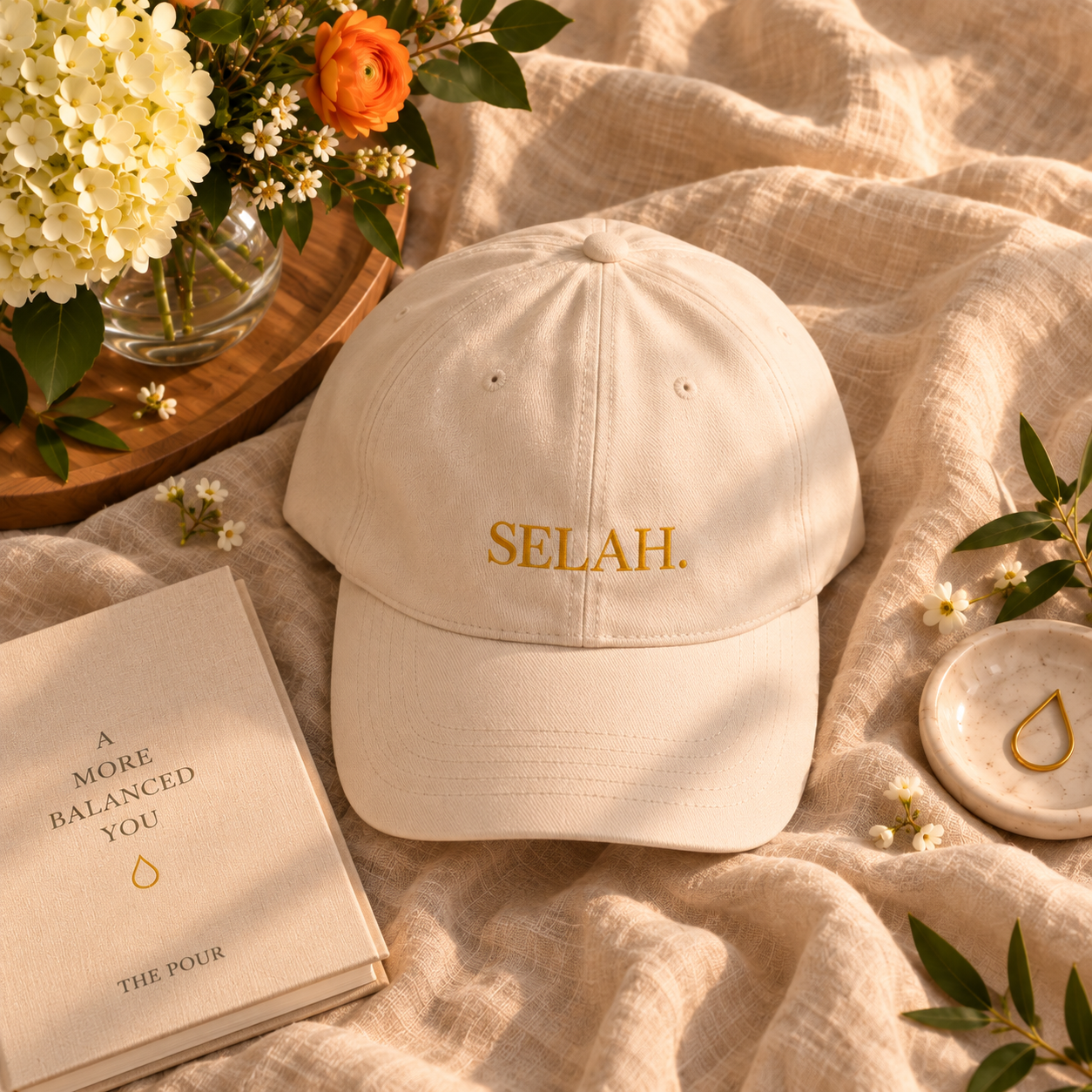 Cream SELAH dad cap next to a journal and trinket dish